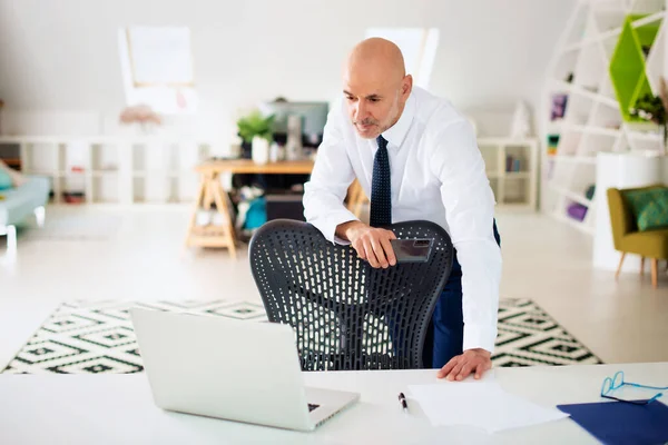 Σκεπτόμενος Επιχειρηματίας Που Στέκεται Στο Γραφείο Και Χρησιμοποιεί Φορητό Υπολογιστή — Φωτογραφία Αρχείου