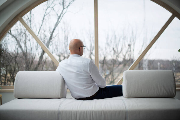 Rear View Shot Thinking Man Sitting Sofa While Looking Out Stock Image