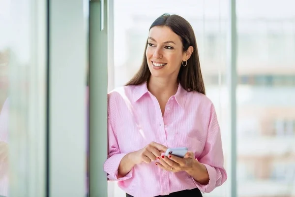 Attractive Businesswoman Looking Thoughtfully While Text Messaging Office — Zdjęcie stockowe