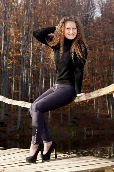 Meisje op een houten brug — Stockfoto