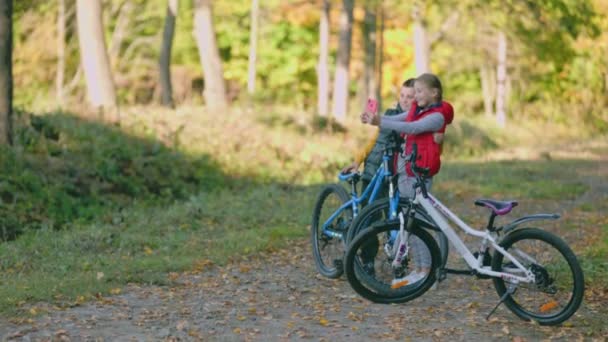 森の中の携帯電話で自転車を持った子供たちが撮影され — ストック動画