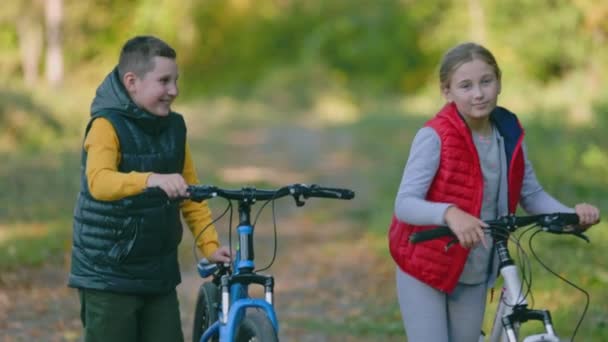 Діти гуляють з велосипедами — стокове відео