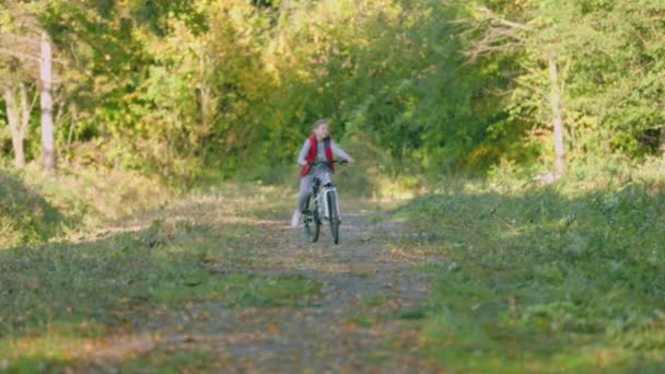 Dziewczyna jazda na rowerze w pobliżu lasu — Wideo stockowe