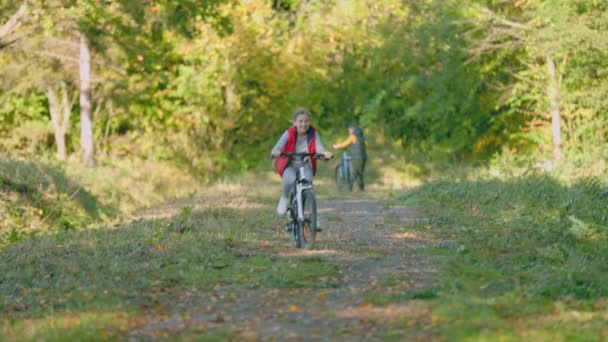 Dzieci jeździć na rowerach w pobliżu lasu — Wideo stockowe