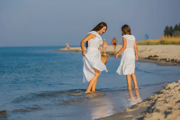 Mam en dochter lopen op het strand — Stockfoto