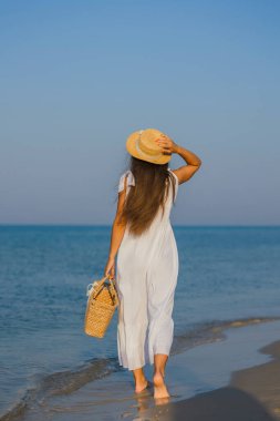 Kumsalda şapkalı bir kadın