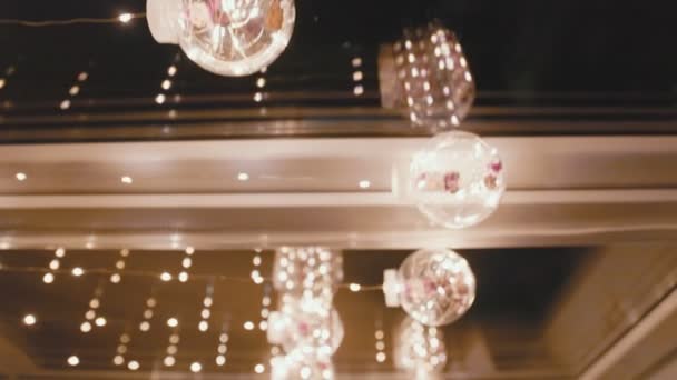 Светящиеся гирлянды в виде шариков на окне — стоковое видео