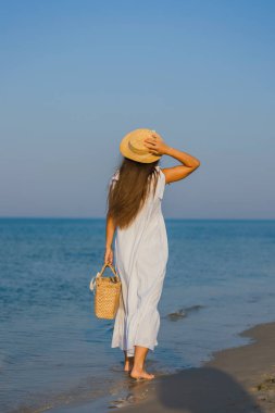 Kumsalda şapkalı bir kadın