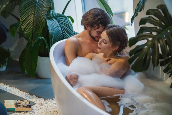 Beautiful couple lies in the bath — 图库照片