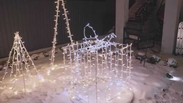 Slingerende bloemenslingers in de vorm van een kerstboom en een geschenk — Stockvideo