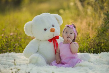 Büyük bir oyuncak ayısı olan küçük bir kız