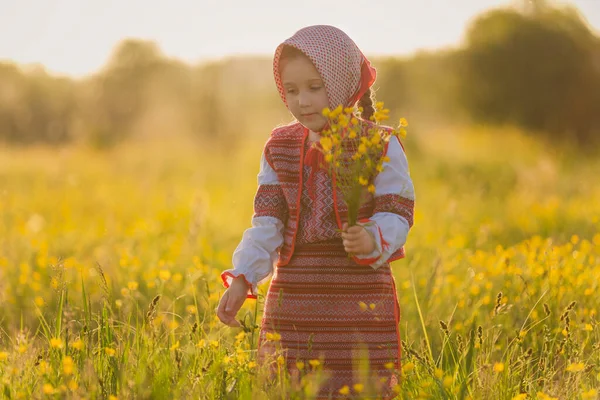 Flicka på gräsmattan med gula blommor — Stockfoto