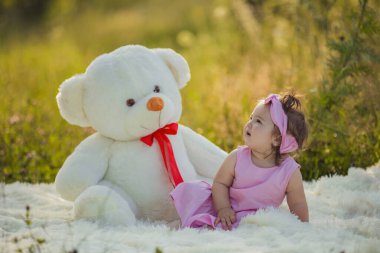 Büyük bir oyuncak ayısı olan küçük bir kız