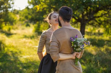 Arkasına buket saklayan bir adam.