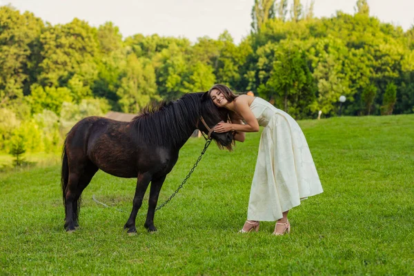 Femme caressant un poney — Photo