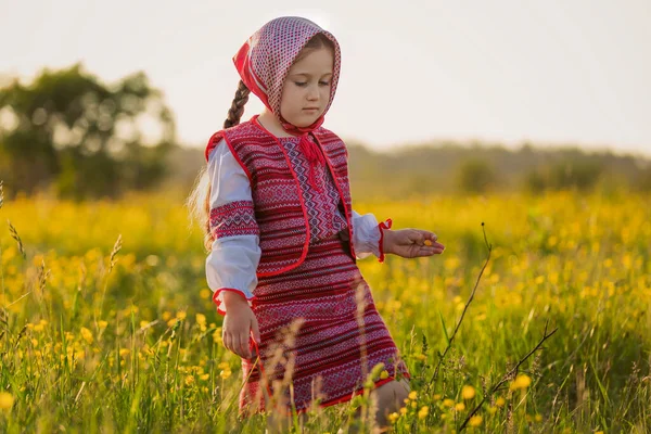 Flicka på gräsmattan med gula blommor — Stockfoto
