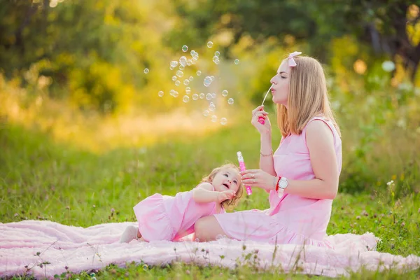 Matka a dcera vyfukuje bubliny — Stock fotografie