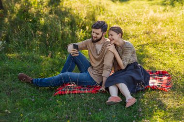 Genç bir çift telefonda selfie çekiyor.