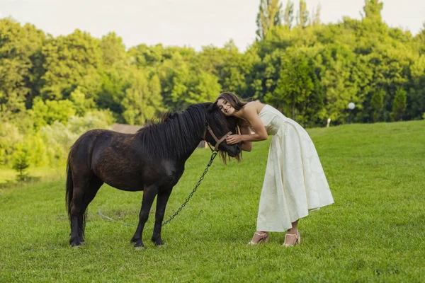 Frau streichelt ein Pony — Stockfoto