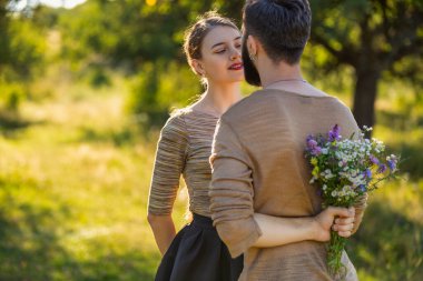 Arkasına buket saklayan bir adam.