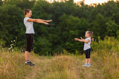 Anne ve kızı doğa egzersiz yaparak