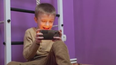Çocuk telefonda oynuyor.