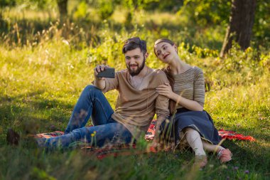 Genç bir çift telefonda selfie çekiyor.