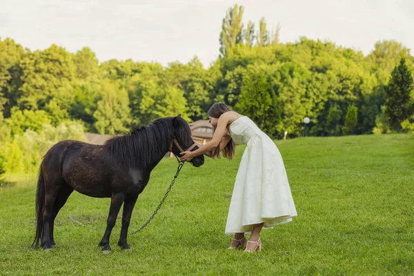 Mujer acariciando un pony — Foto de Stock