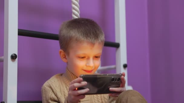 Chłopiec bawiący się przez telefon — Wideo stockowe