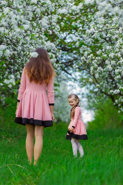 Madre e hija están caminando por el jardín floreciente —  Fotos de Stock