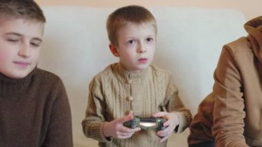 Çocuklar konsolda ruhlarda joysticklerle oynuyorlar.