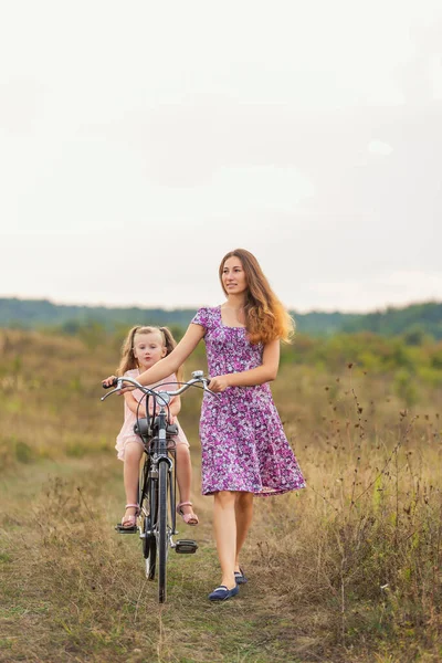 Mom rides daughter on bike — Stock Photo, Image