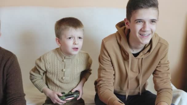 Niños juegan en la consola con joysticks en ruhs — Vídeos de Stock