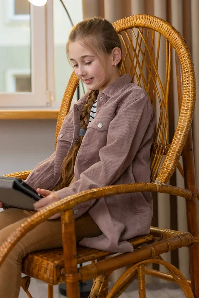 Девушка с планшетом сидит в кресле-качалке — стоковое фото