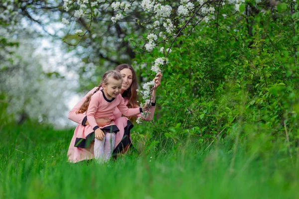 Mutter und Tochter sitzen in einem Apfelgarten — Stockfoto
