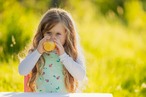 Child drinking orange juice — Stock Photo, Image