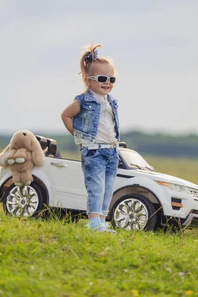 Girl in sunglasses stands in front of a car — Stock Photo, Image