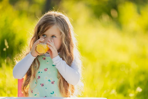 Child drinking orange juice — Stock Photo, Image