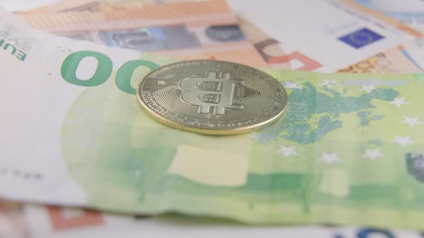 Gouden bitcoin ligt op eurobankbiljetten — Stockvideo
