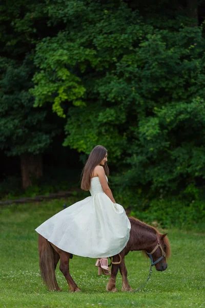 Chica montando un pony — Foto de Stock