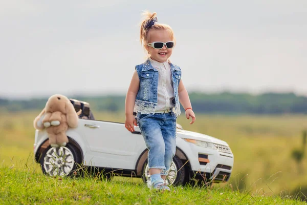 Mädchen mit Sonnenbrille steht vor Auto — Stockfoto