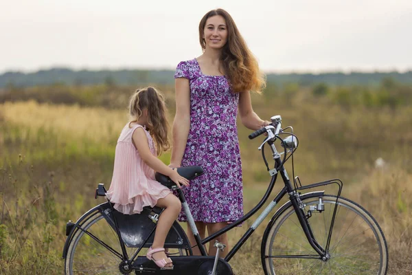 母は娘を自転車に乗せて — ストック写真