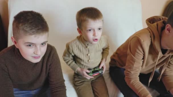 Niños juegan en la consola con joysticks en ruhs — Vídeo de stock