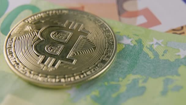 Gouden bitcoin ligt op eurobankbiljetten — Stockvideo