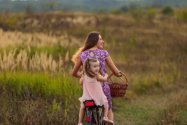 Мама катается на велосипеде с дочерью — стоковое фото