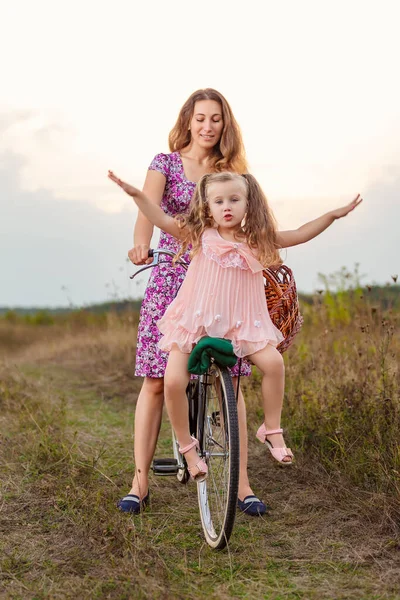 Mom rides her daughter on a bike — Stock Photo, Image