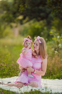 Anne ve kızı pembe elbiseli.
