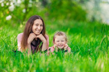 Anne ve kızı çimenlerde yatıyor.