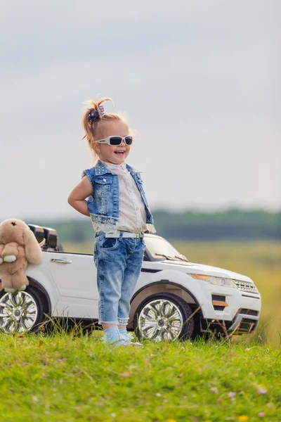 Mädchen mit Sonnenbrille steht vor Auto — Stockfoto