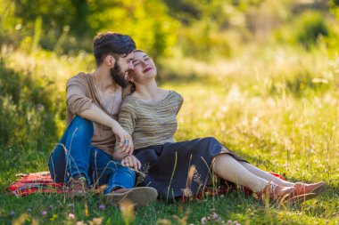 Genç çift doğada oturuyor.